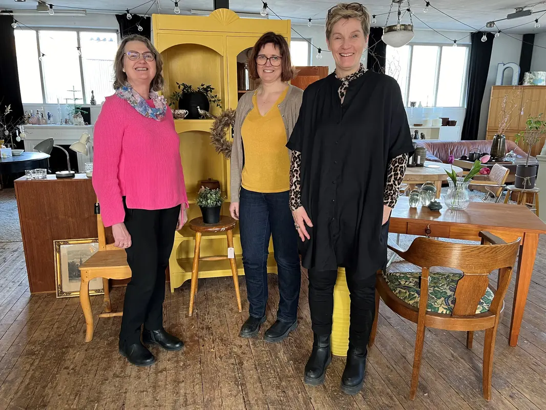 Marie Wilén, Emma Burstedt och Camilla Andersson står i butiken omgiven av återbrukade möbler.