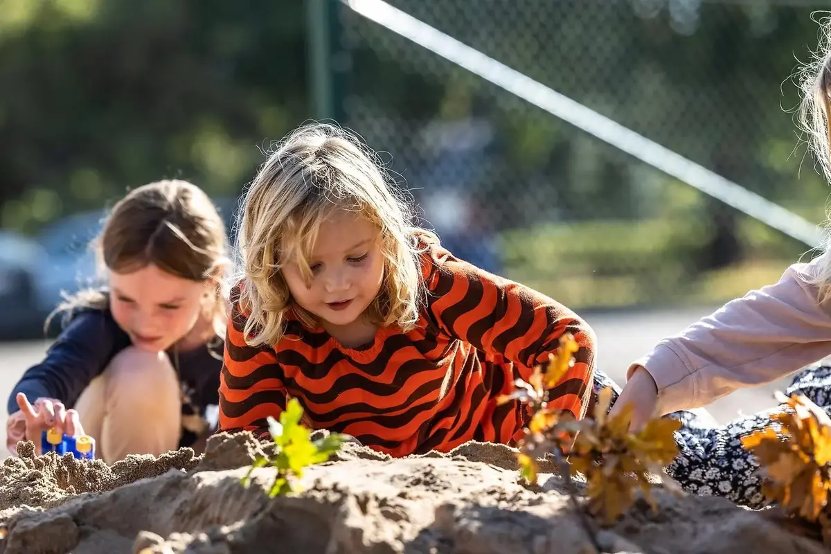 Barn gräver i sandlåda