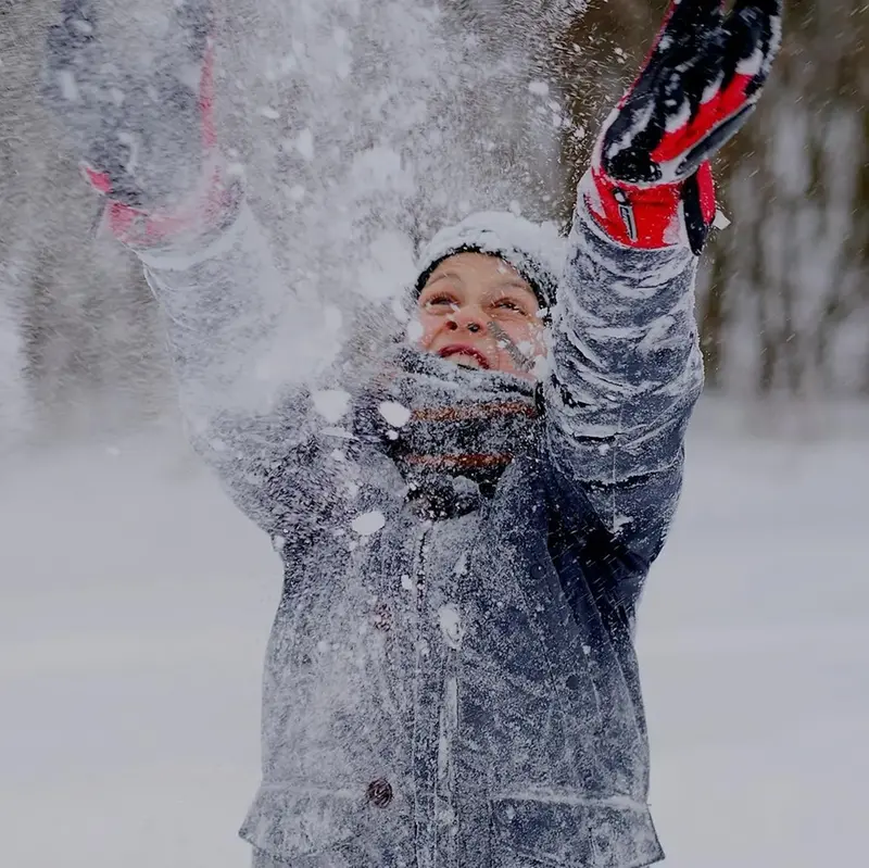 Barn kastar upp snö i luften
