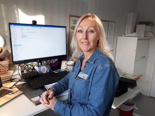 Maria Byström, rektor Vittinge förskola och skola står vid sitt skrivbord och ler in i kameran.
