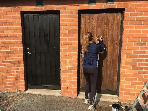 Tjej målar dörr 