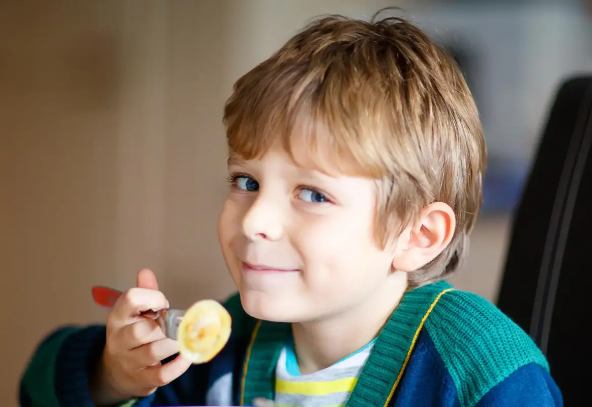 Liten pojke äter pasta